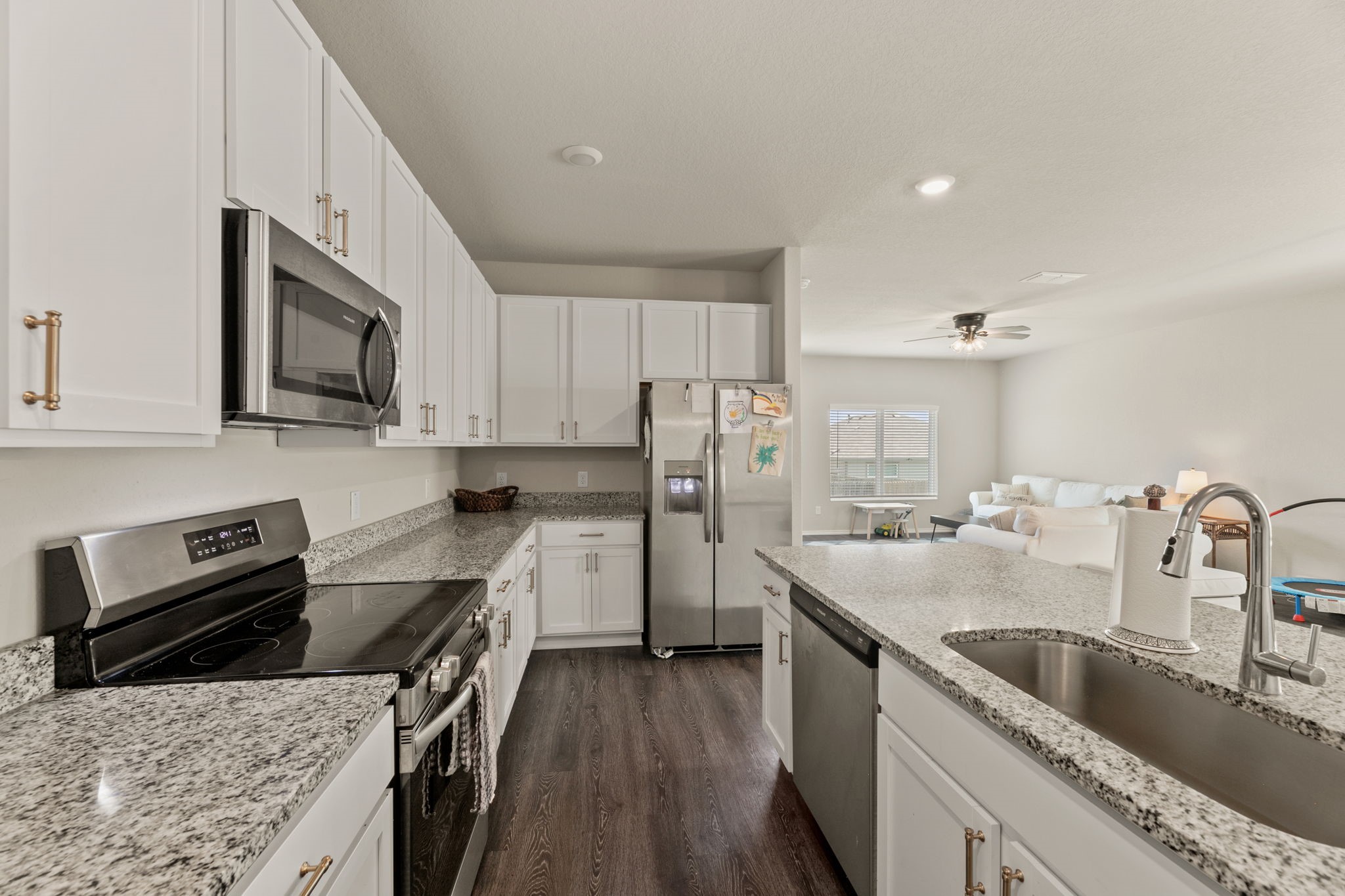 3969 Legend Ranch New Braunfels, TX 78130 - Photo 10 of 32 a kitchen with stainless steel appliances granite countertop a sink stove microwave and refrigerator