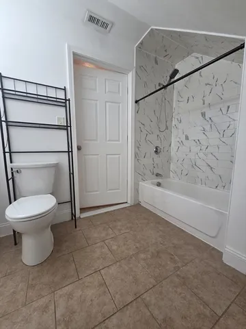 a bathroom with a toilet and a shower