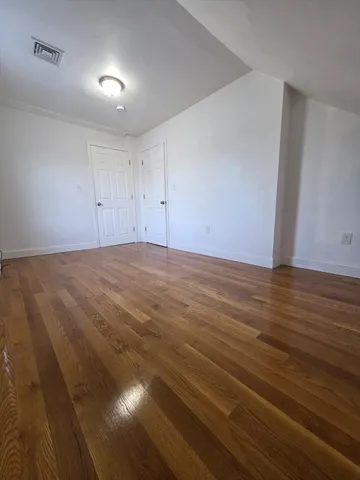 a view of an empty room and wooden floor