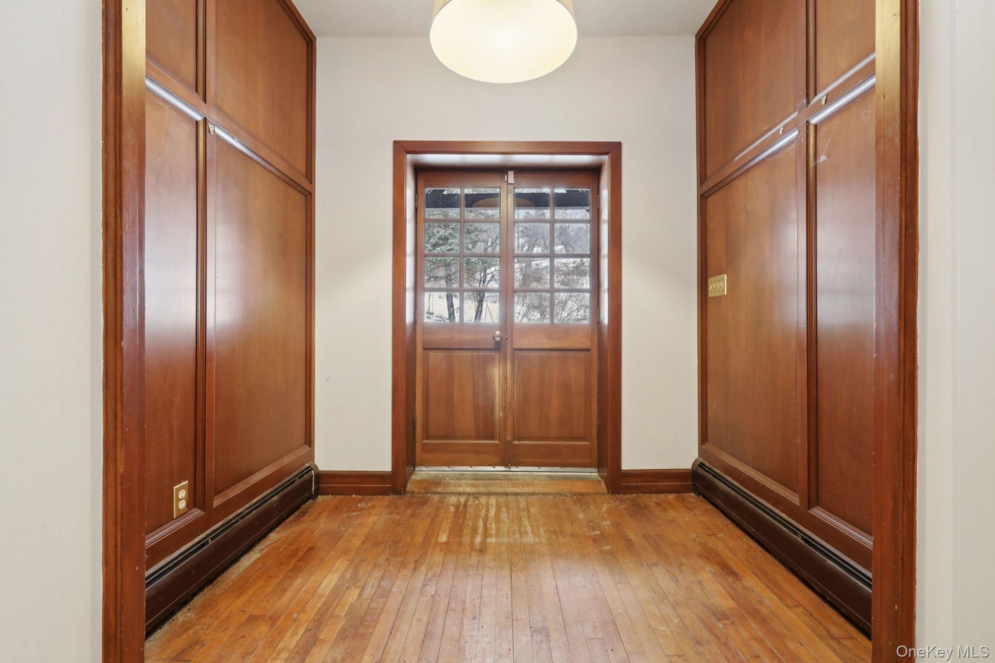 32 East Lake Stable Road Tuxedo Park, NY 10987 - Photo 3 of 49 an empty room with wooden floor and windows