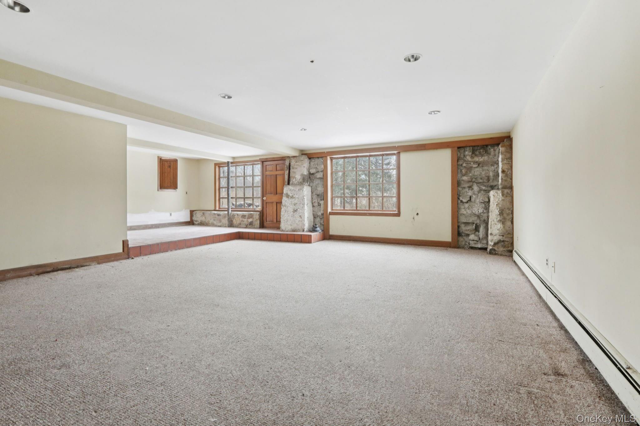32 East Lake Stable Road Tuxedo Park, NY 10987 - Photo 39 of 49 a view of a big room with windows and chandelier fan