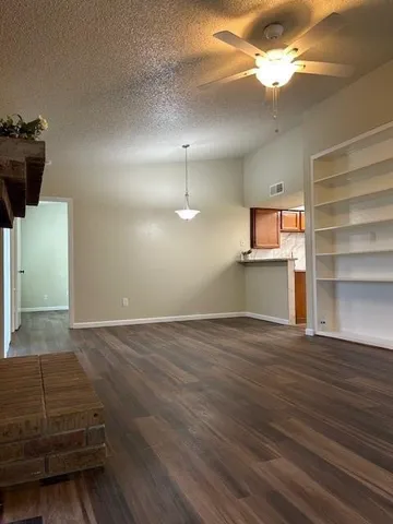 a view of a livingroom with a ceiling fan and wooden floor
