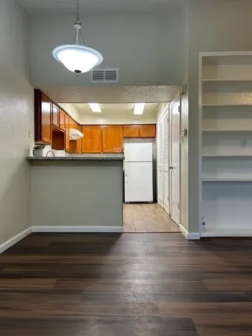 a view of room with wooden floor and chandelier