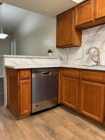 a kitchen with granite countertop wood cabinets and a sink