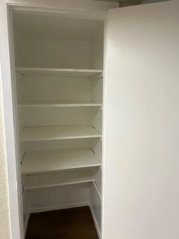 a view of walk in closet with empty racks