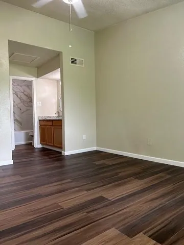 a view of empty room with wooden floor and fireplace