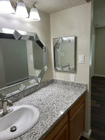 a bathroom with a granite countertop sink and a mirror
