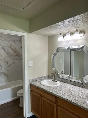 a bathroom with a granite countertop sink and a mirror