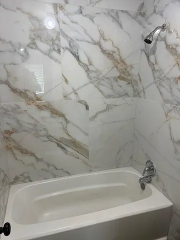 a bathroom with bathtub and shower