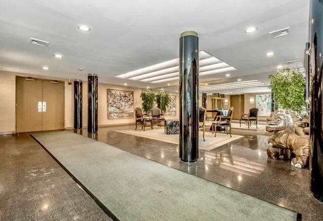 a view of a hall with living room and chandelier