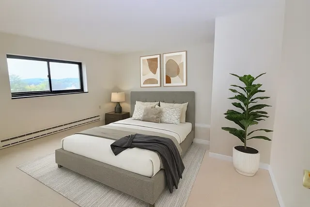 a bedroom with bed and a potted plant