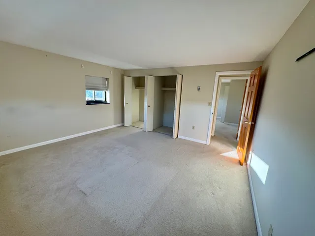 an empty room with windows and closet