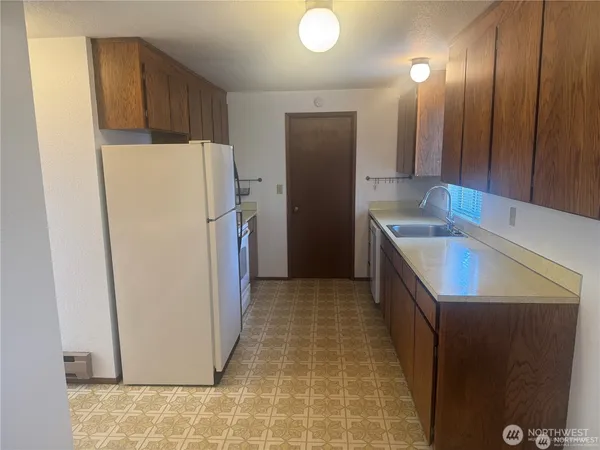 a kitchen with a refrigerator sink and cabinets