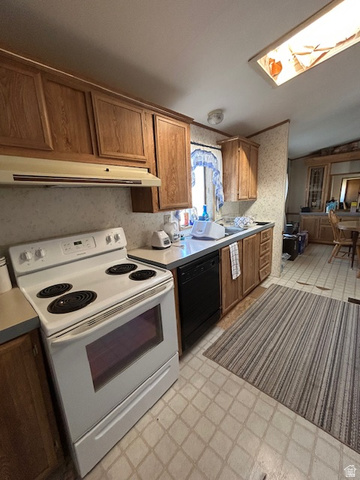 1690 Lower Boulder Road Boulder, UT 84716 - Photo 7 of 13 Kitchen with white electric range oven, light floors, brown cabinets & dishwasher