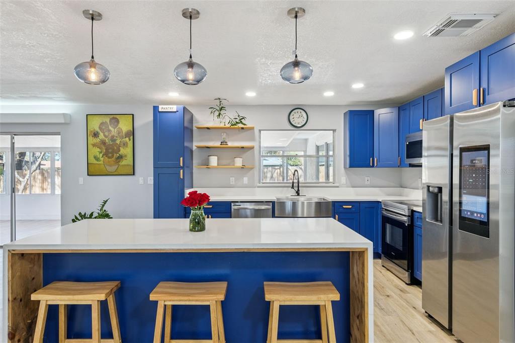549 Iris Street Altamonte Springs, FL 32714 - Photo 11 of 28 a kitchen with stainless steel appliances granite countertop wooden cabinets a stove a sink and a center island