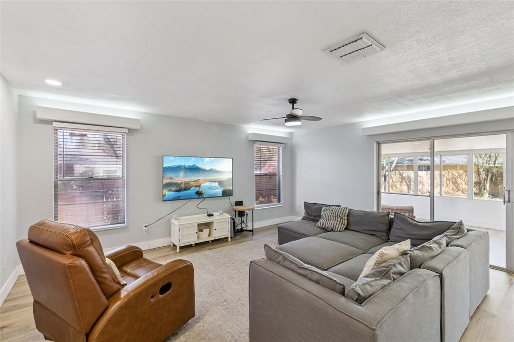 549 Iris Street Altamonte Springs, FL 32714 - Photo 7 of 28 a living room with furniture a large window and a flat screen tv