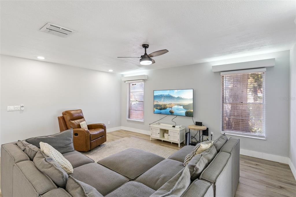 549 Iris Street Altamonte Springs, FL 32714 - Photo 8 of 28 a living room with furniture a large window and flat screen tv