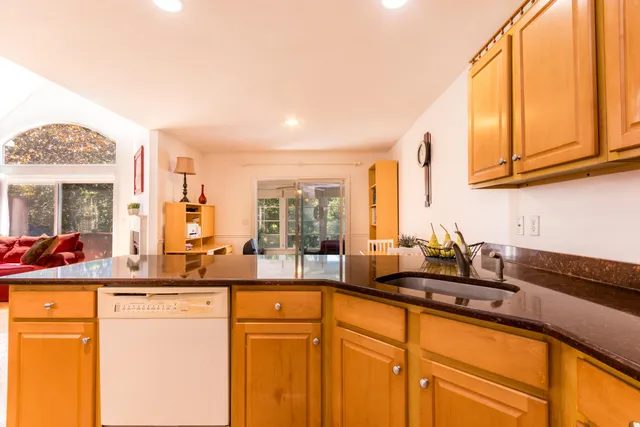 a kitchen with stainless steel appliances granite countertop a sink and a stove