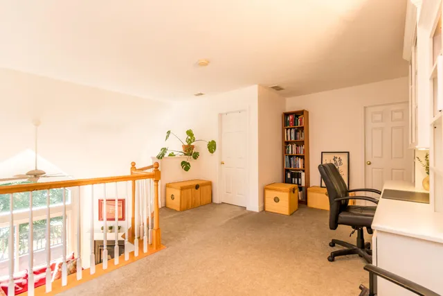 a view of a workspace with furniture and a window