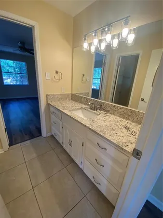 a bathroom with a granite countertop sink and a mirror