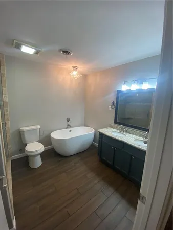 a spacious bathroom with a toilet sink and mirror