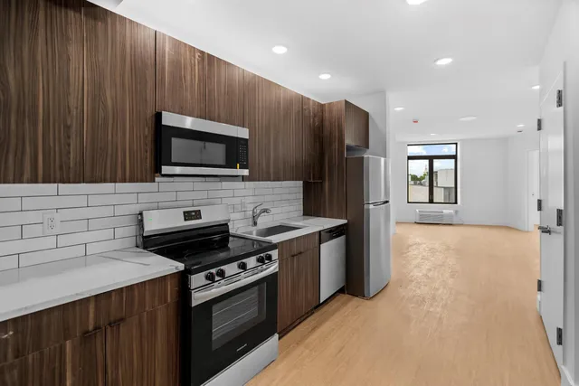 a kitchen with a stove a microwave a sink and a refrigerator