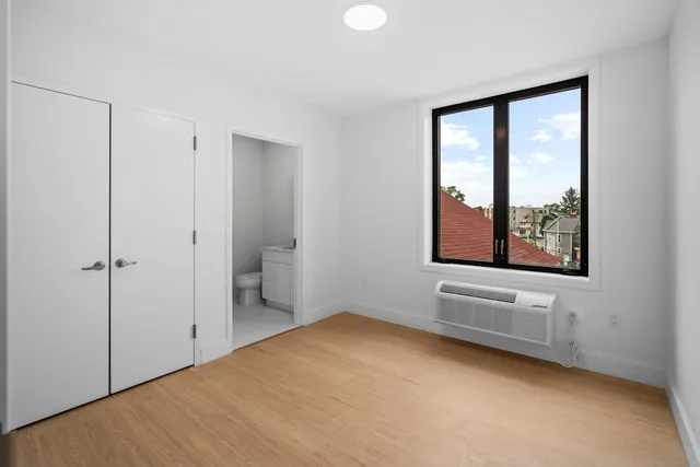 a view of an empty room with window and closet area