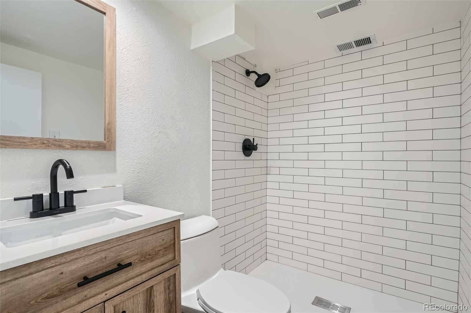 1720 South Java Way Denver, CO 80219 - Photo 17 of 28 a bathroom with a toilet sink and mirror