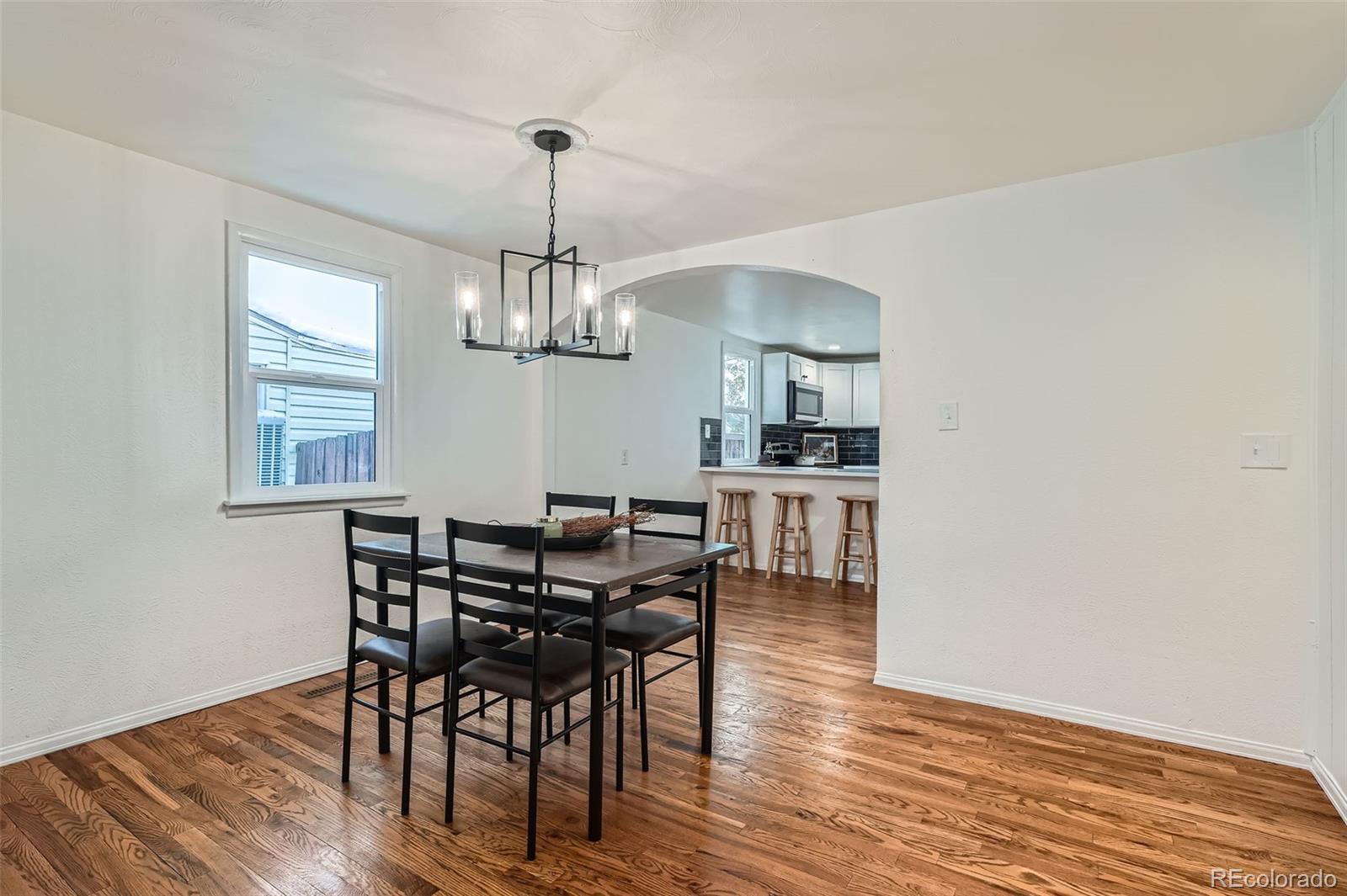 1720 South Java Way Denver, CO 80219 - Photo 4 of 28 a view of a dining room with furniture wooden floor and chandelier