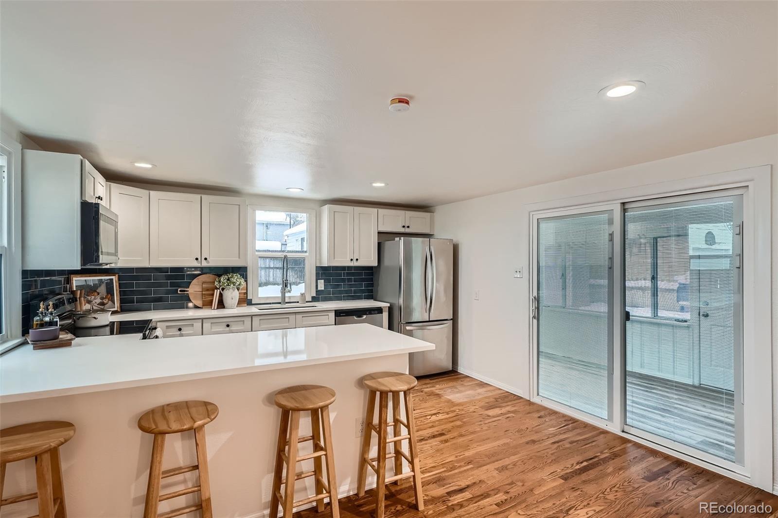 1720 South Java Way Denver, CO 80219 - Photo 7 of 28 a kitchen with stainless steel appliances granite countertop a refrigerator and a stove top oven