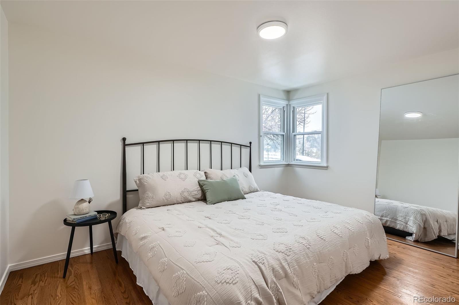 1720 South Java Way Denver, CO 80219 - Photo 9 of 28 a bedroom with a bed and wooden floor