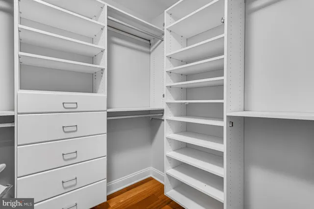 a view of walk in closet with empty racks