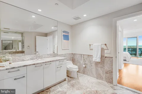 a spacious bathroom with a granite countertop sink mirror and toilet