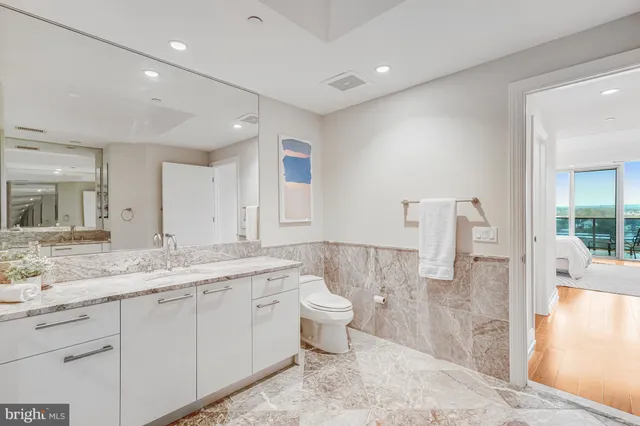 a spacious bathroom with a granite countertop sink mirror and toilet