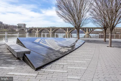 a view of a lake from a balcony with outdoor seating