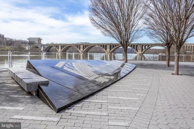 a view of a lake from a balcony with outdoor seating