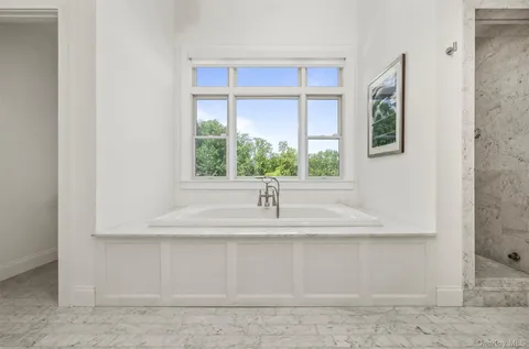 a bedroom with bed and a large window