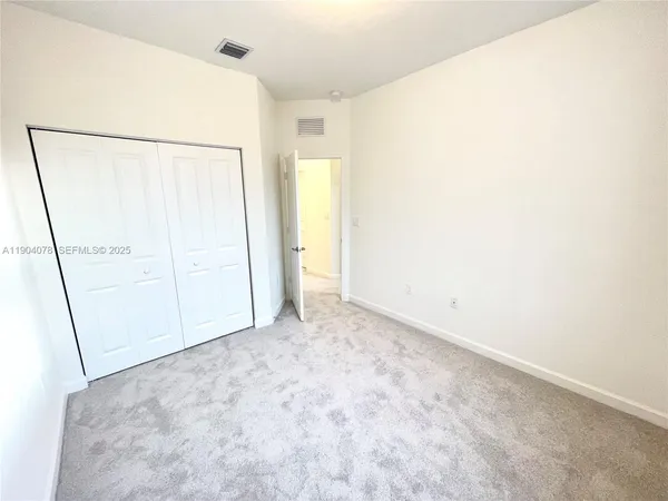 a view of a big room with closet and windows