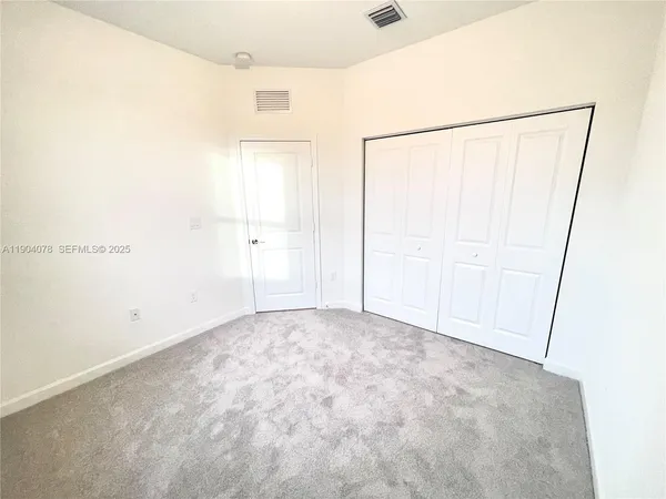 an empty room with windows and closet