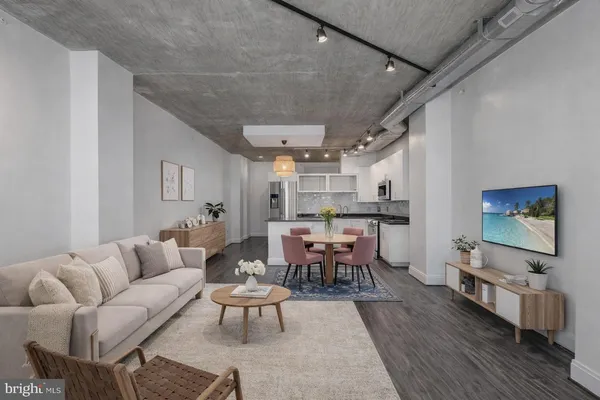 a living room with furniture a wooden floor and a dining table