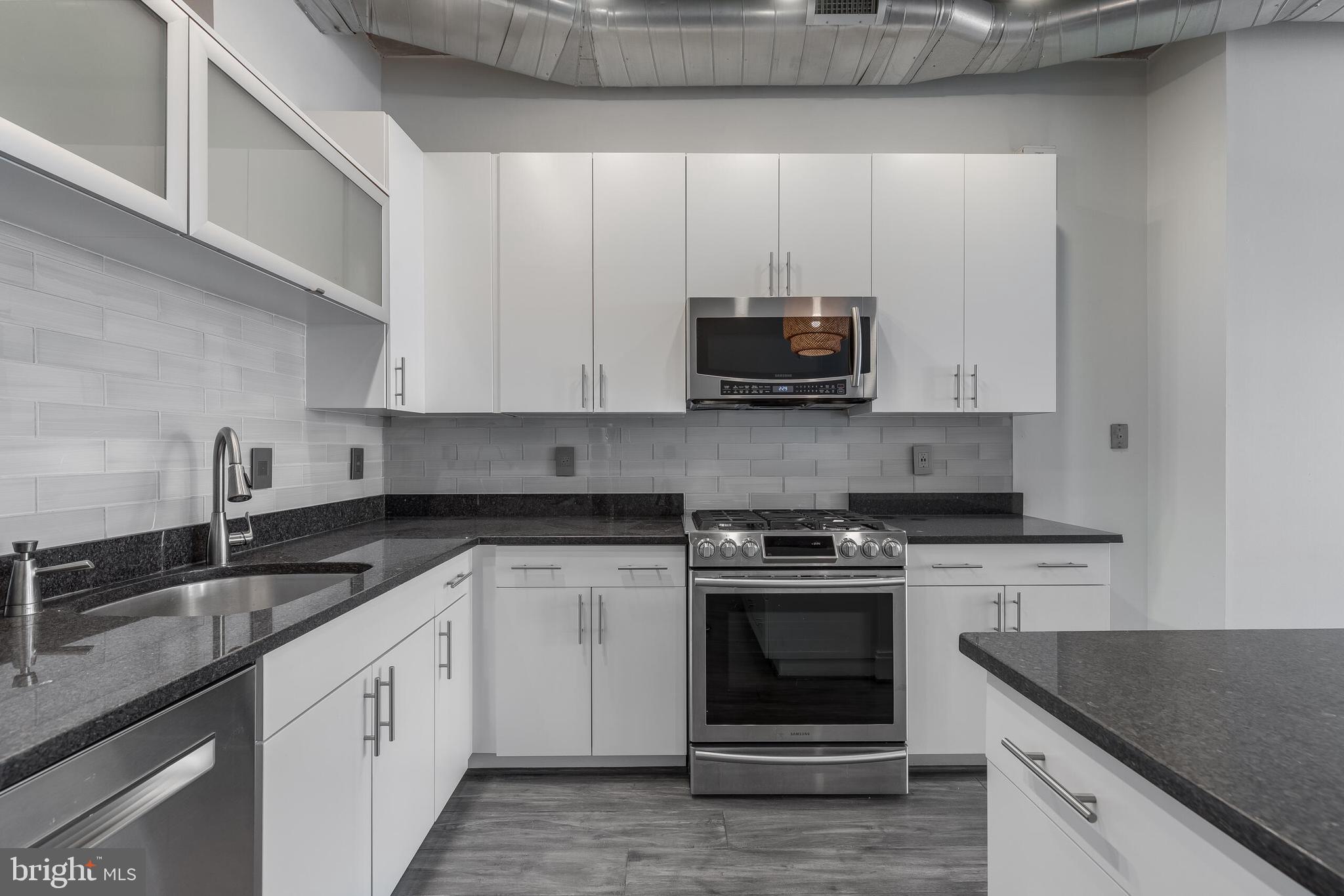 929 Florida Avenue Northwest, Unit 2001 Washington, DC 20001 - Photo 13 of 42 a kitchen with stainless steel appliances granite countertop a sink stove and microwave