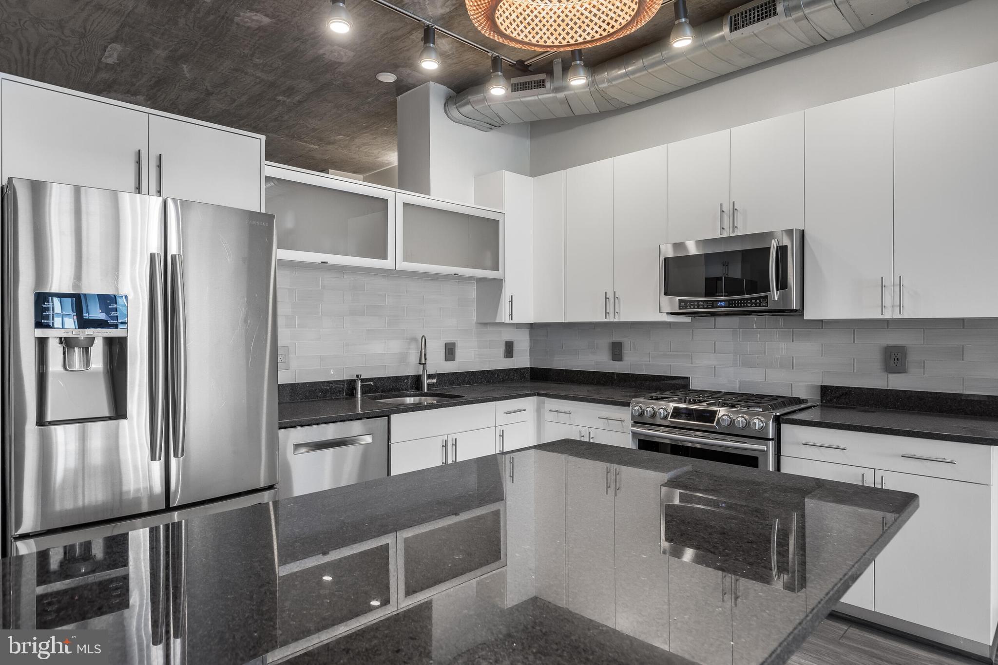 929 Florida Avenue Northwest, Unit 2001 Washington, DC 20001 - Photo 16 of 42 a kitchen with stainless steel appliances granite countertop a refrigerator a stove and a microwave