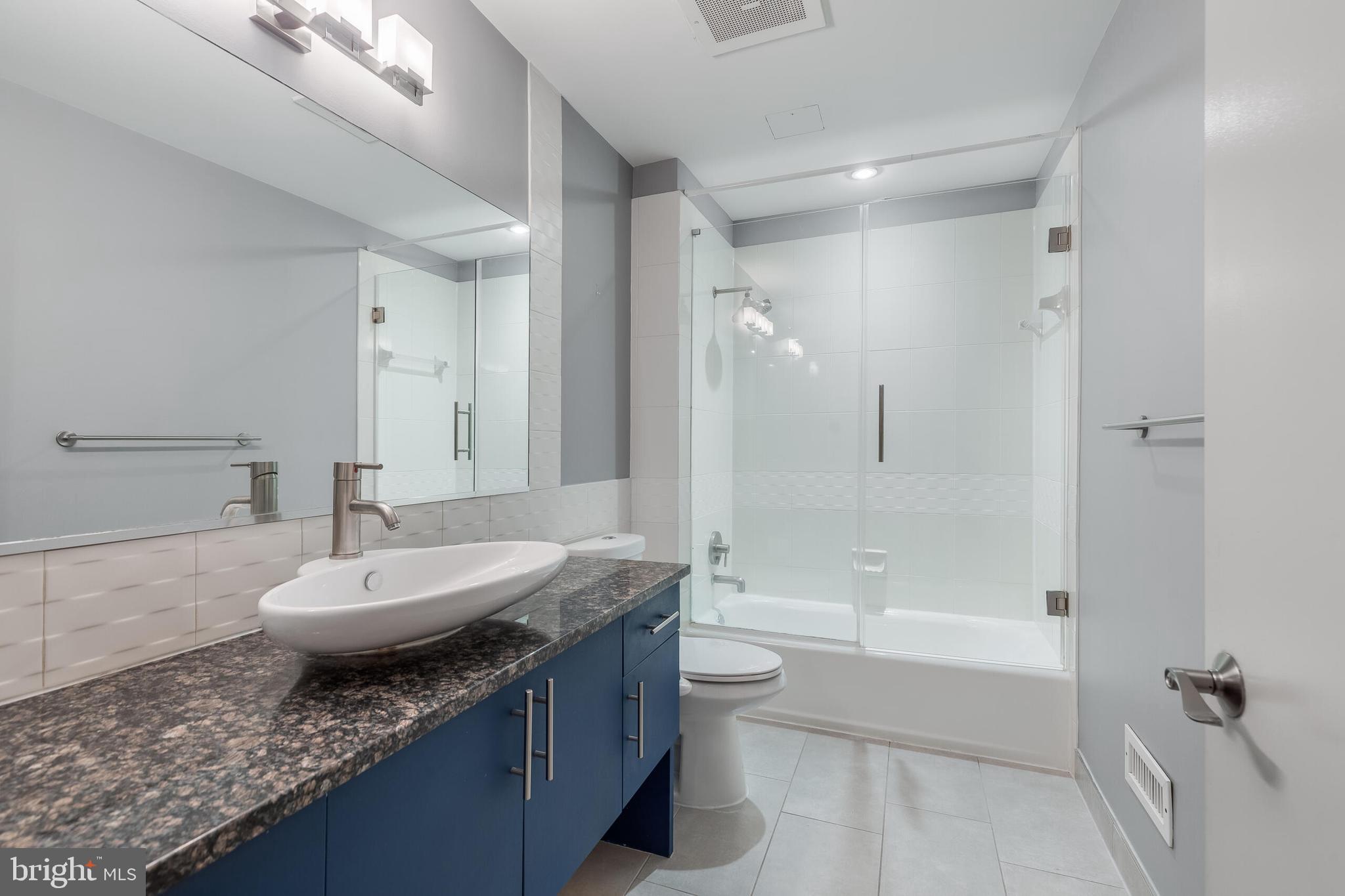 929 Florida Avenue Northwest, Unit 2001 Washington, DC 20001 - Photo 20 of 42 a spacious bathroom with a granite countertop tub sink and mirror