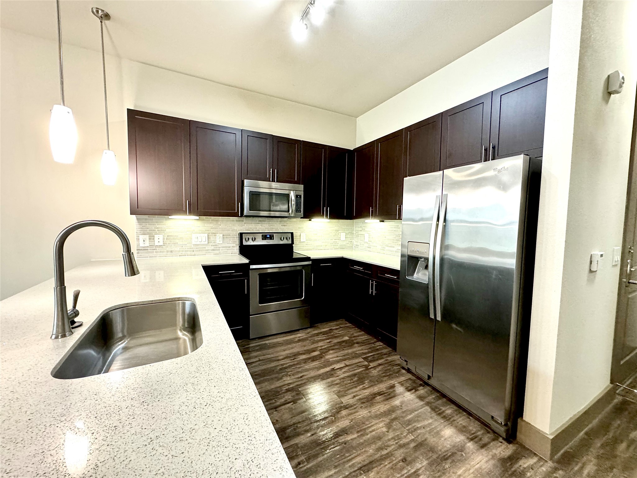 2033 South Gessner Road, Unit 2108 Houston, TX 77063 - Photo 4 of 21 a kitchen with a refrigerator sink and wooden floor