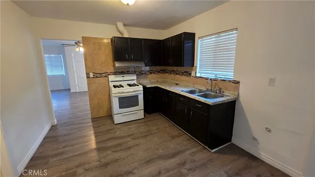 a kitchen with a sink stove top oven and cabinets