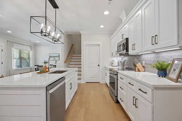 a kitchen with white cabinets and appliances