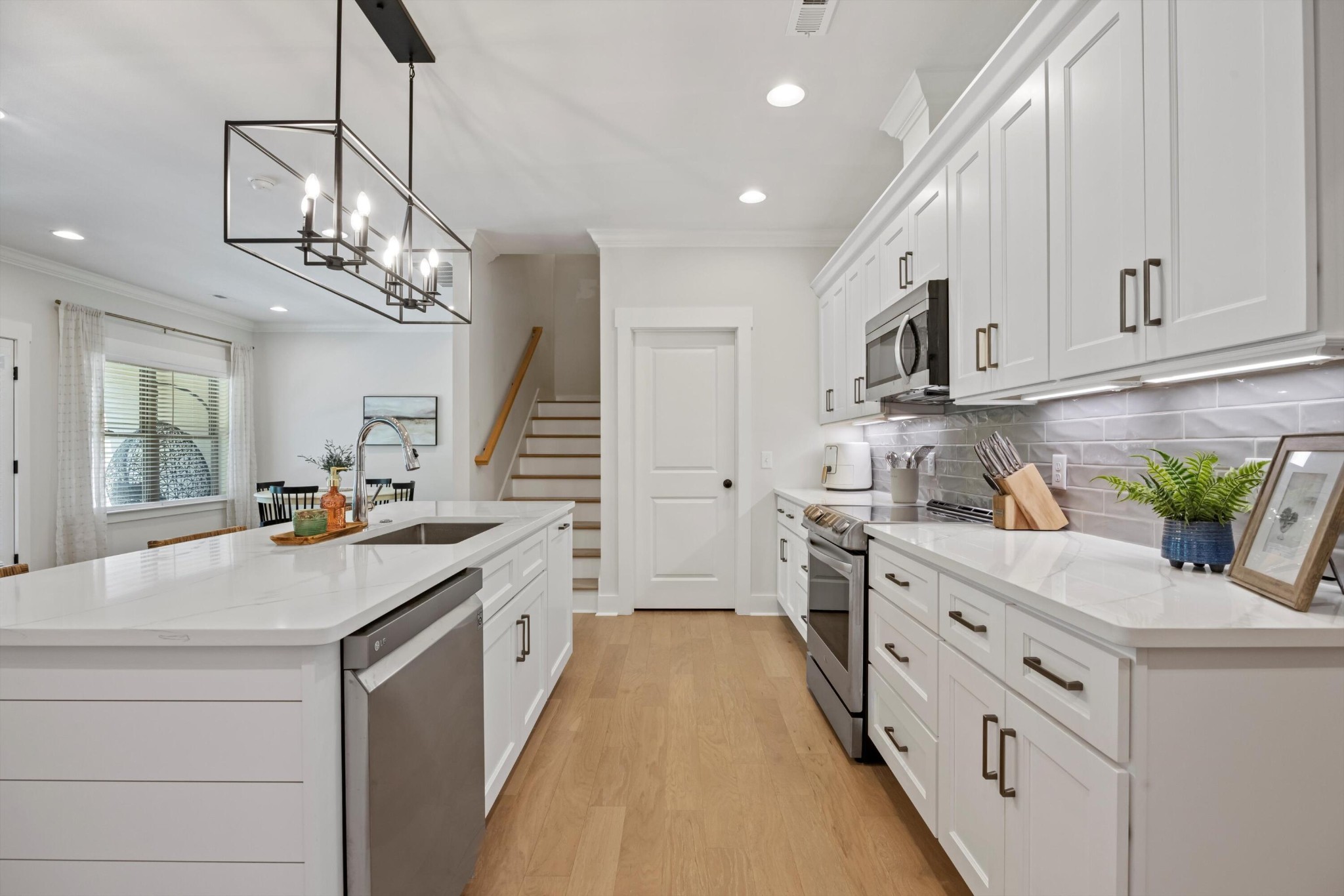 9638 Dutton Lane Ooltewah, TN 37363 - Photo 12 of 38 a kitchen with stainless steel appliances kitchen island granite countertop a sink a stove and a wooden floors