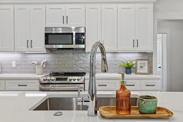 a kitchen with cabinets stainless steel appliances and wooden floor
