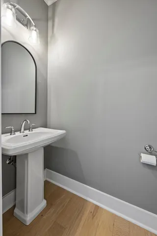 a hallway with white cabinets and wooden floor