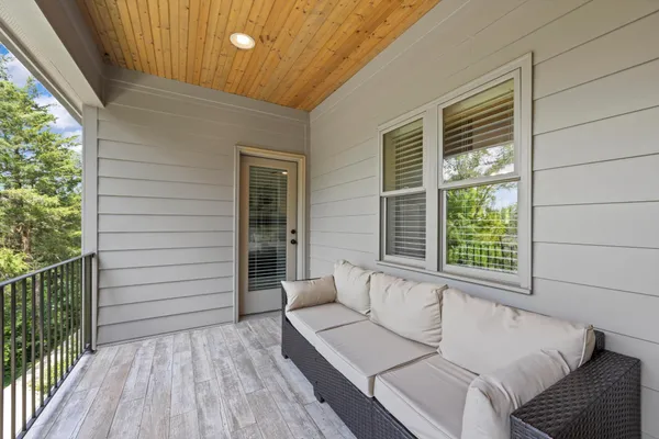 a view of a balcony with floor to ceiling window and wooden floor